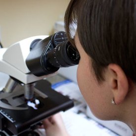 Technicienne regardant dans le microscope